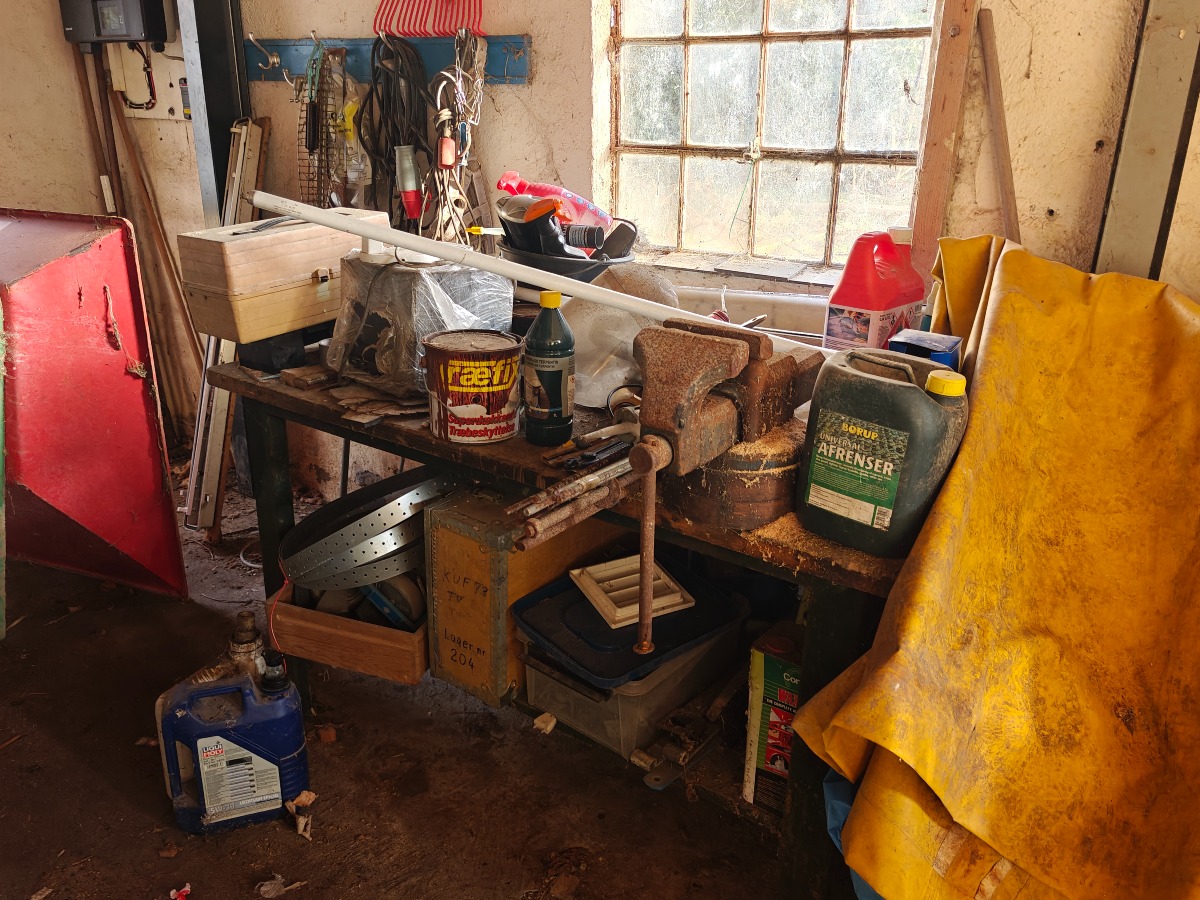 Værkstedsbord m/skruetvinge. Indhold på bord, knager og på gulv t.h. for bord medfølger.  