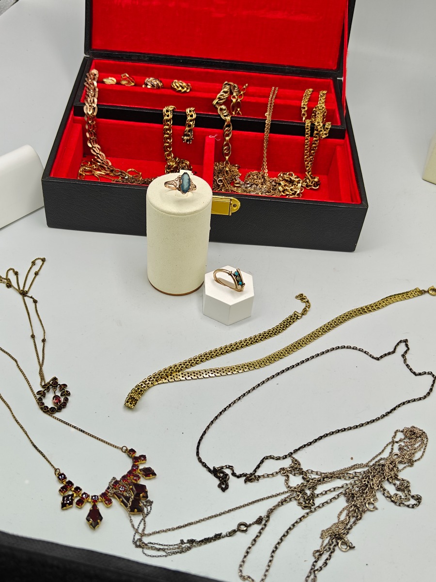 Smykkeskrin med guld-double halskæder, ringe og øreklips.