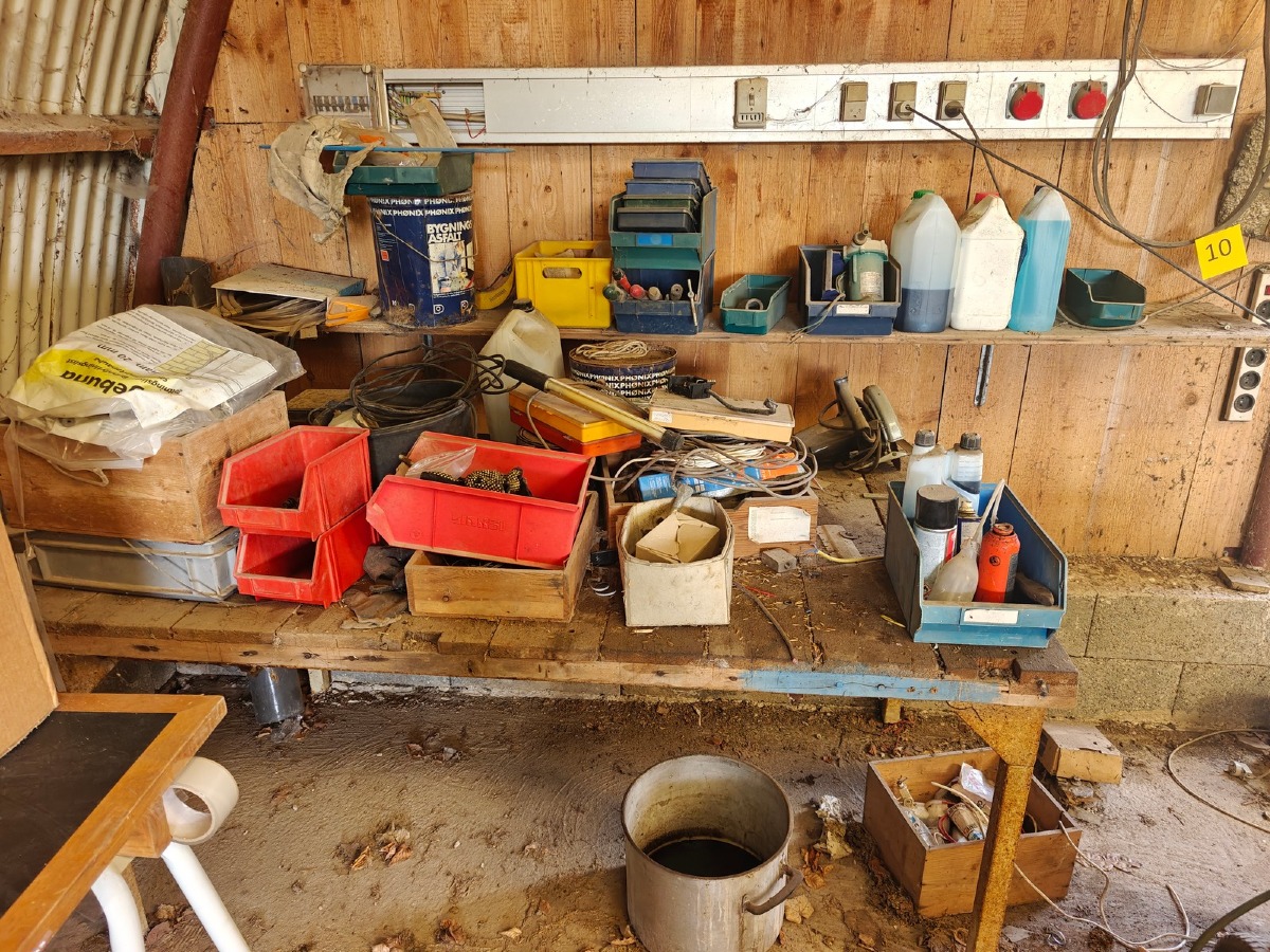 Tøm bord og langs væg. Høvlebænk, stålplader, håndværktøj, kabler, slanger, skinner mm. Brugt