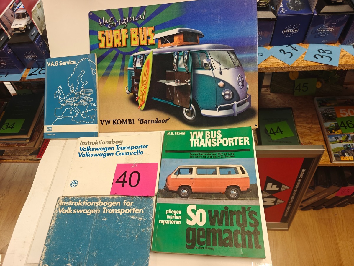 VW: Instruktionsbøger til div VW transporter og bus veteran modeller samt metalskilt med VW motiv.