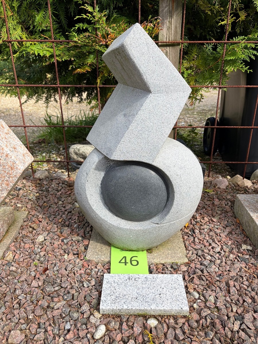 Abstrakt skulptur af sort granit med delvis poleret overflade