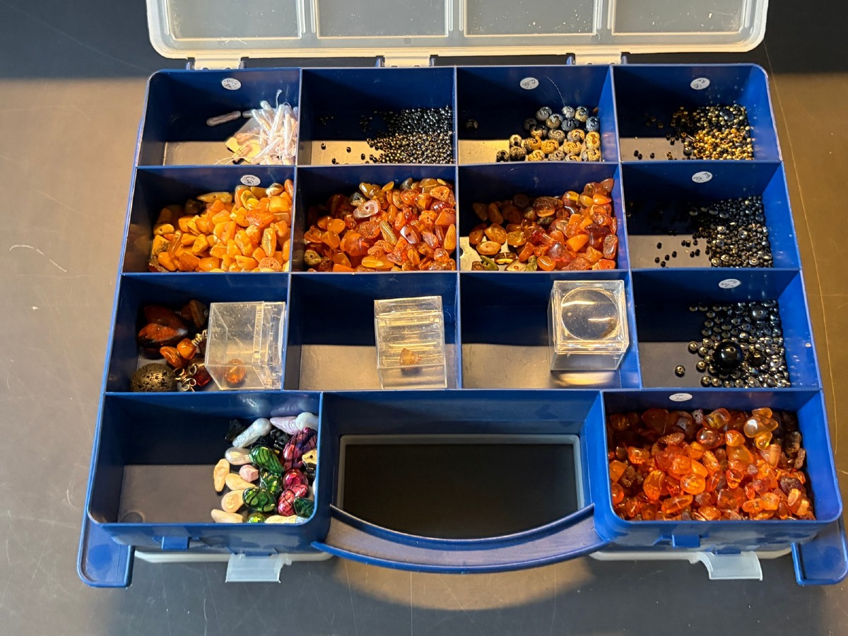Kasse med rav, perler, sten og diverse smykkedele